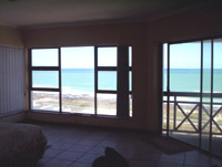 The view of the sea in the main bedroom with the window on the left and the sliding door to the balcony on the right