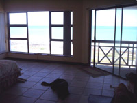 The view of the sea in the main bedroom with the window on the left and the sliding door to the balcony on the right